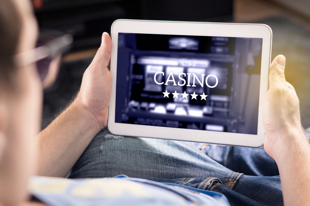 Man playing in an online casino with tablet. Modern gambling application.